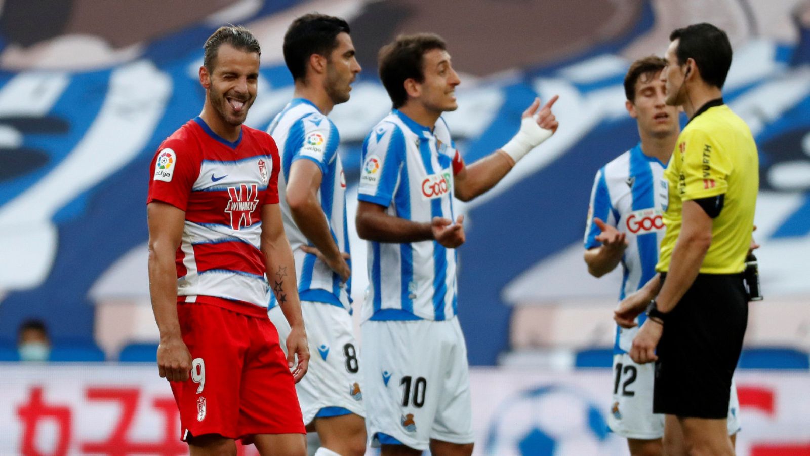 El capitán y delantero de la Real Sociedad, Mikel Oyarzabal (c), protesta al árbitro Martínez Munuera (d) por conceder el gol de Soldado (i), delantero del Granada