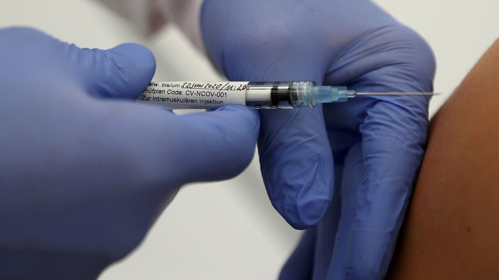 Un médico inyecta una vacuna en fase de prueba clínica a un voluntario