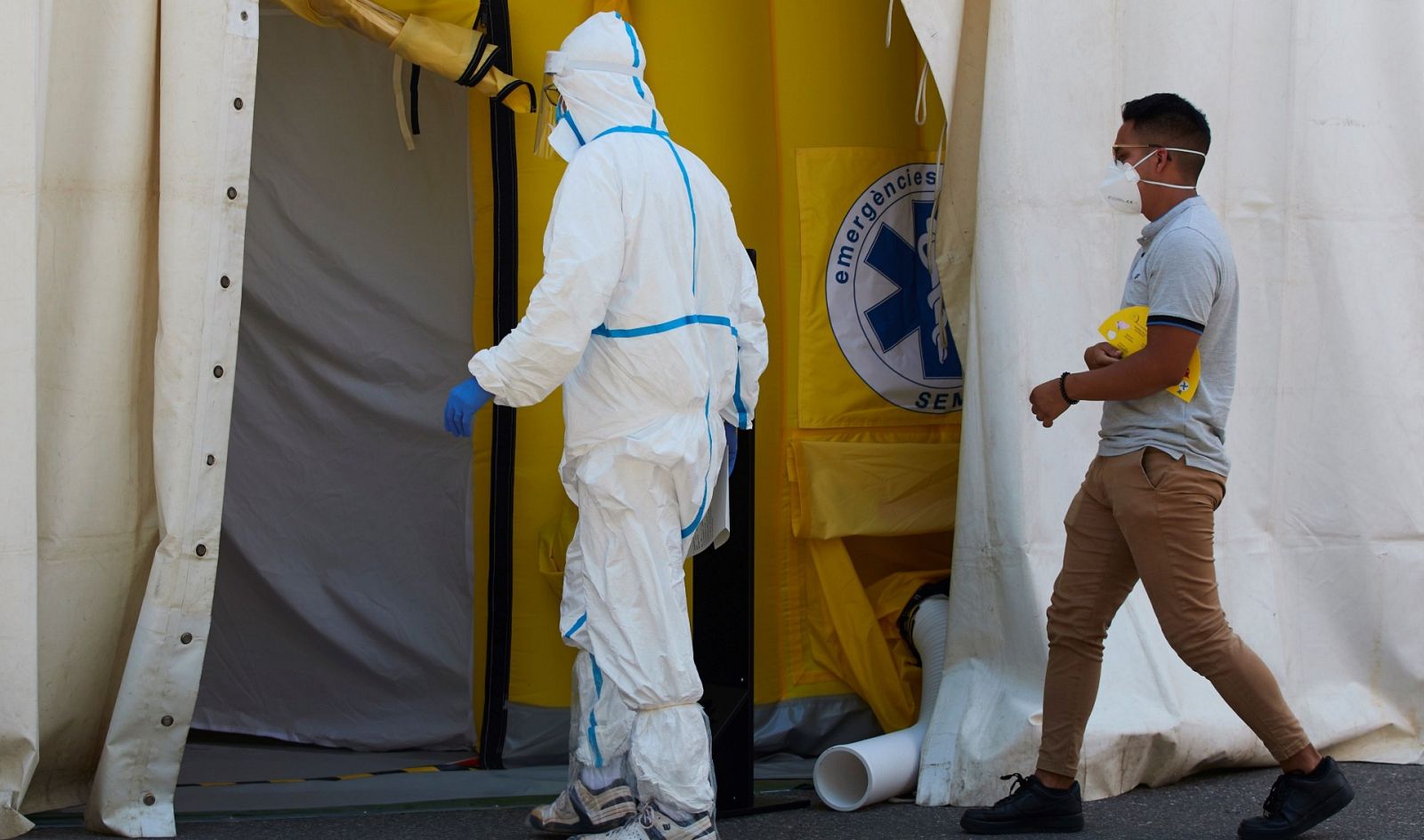 Un sanitario y un paciente entran en el hospital de campaña en Lleida