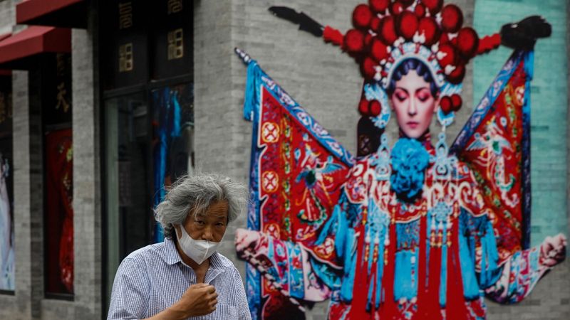 Un hombre con mascarilla caminando por una calle de Pekín, China.