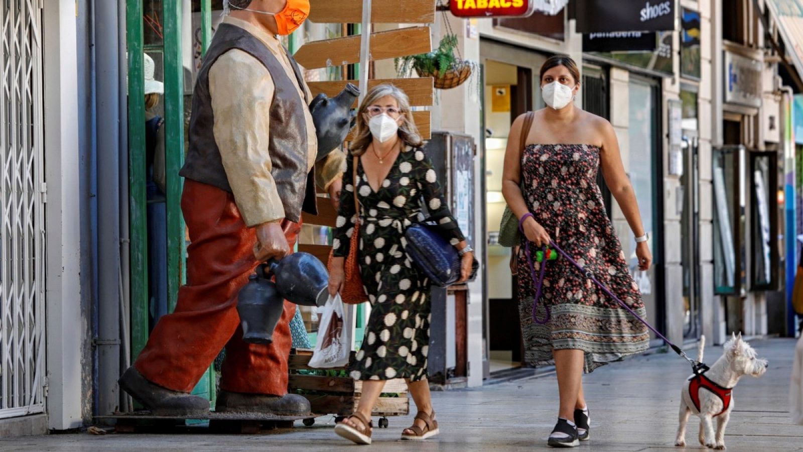 Dos mujeres pasean con mascarilla por una calle de Cataluña