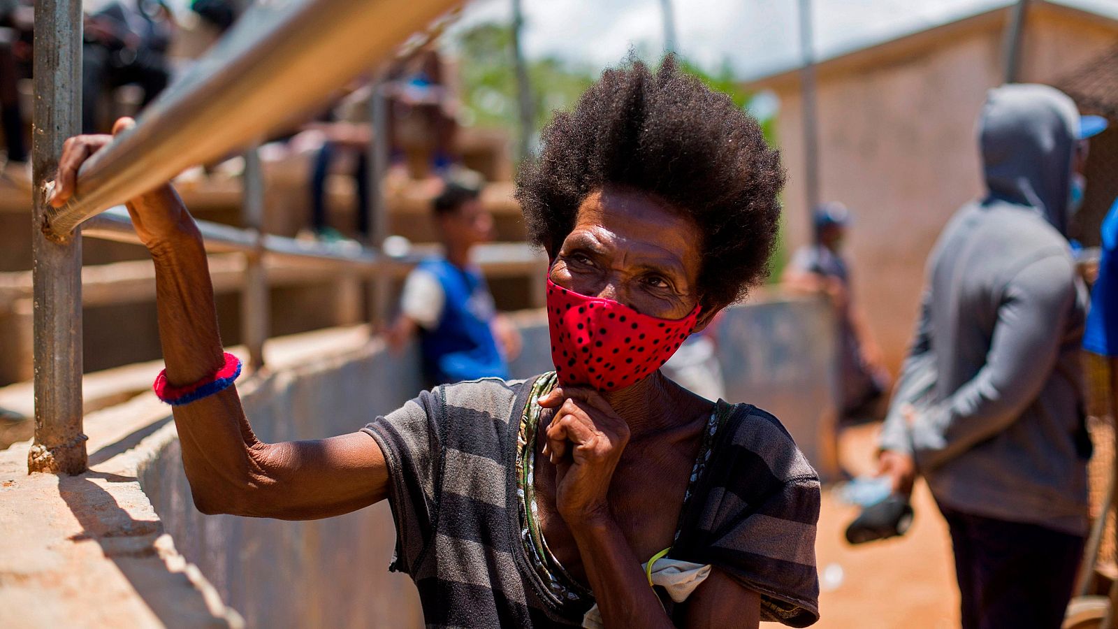 Una mujer usa mascarillas contra la propagación del coronavirus mientras asiste a un partido de béisbol en Boca Chica, República Dominicana