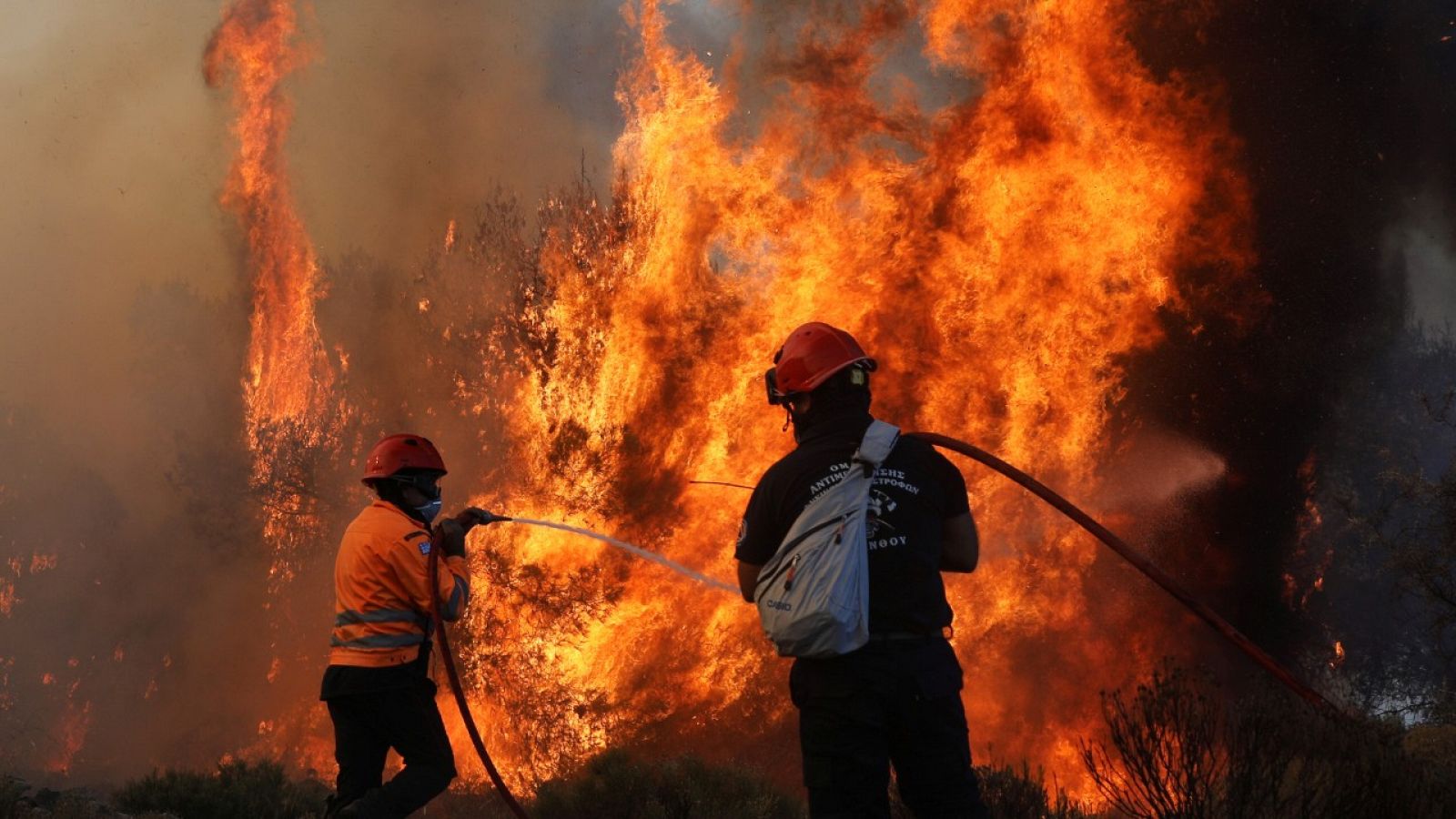 Dos bomberos luchando contra las llamas en Kechries, Grecia.