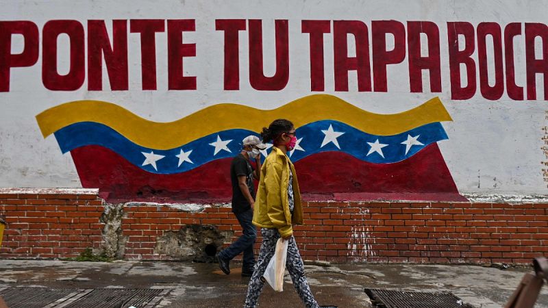 Dos personas caminan por una calle del centro de Caracas