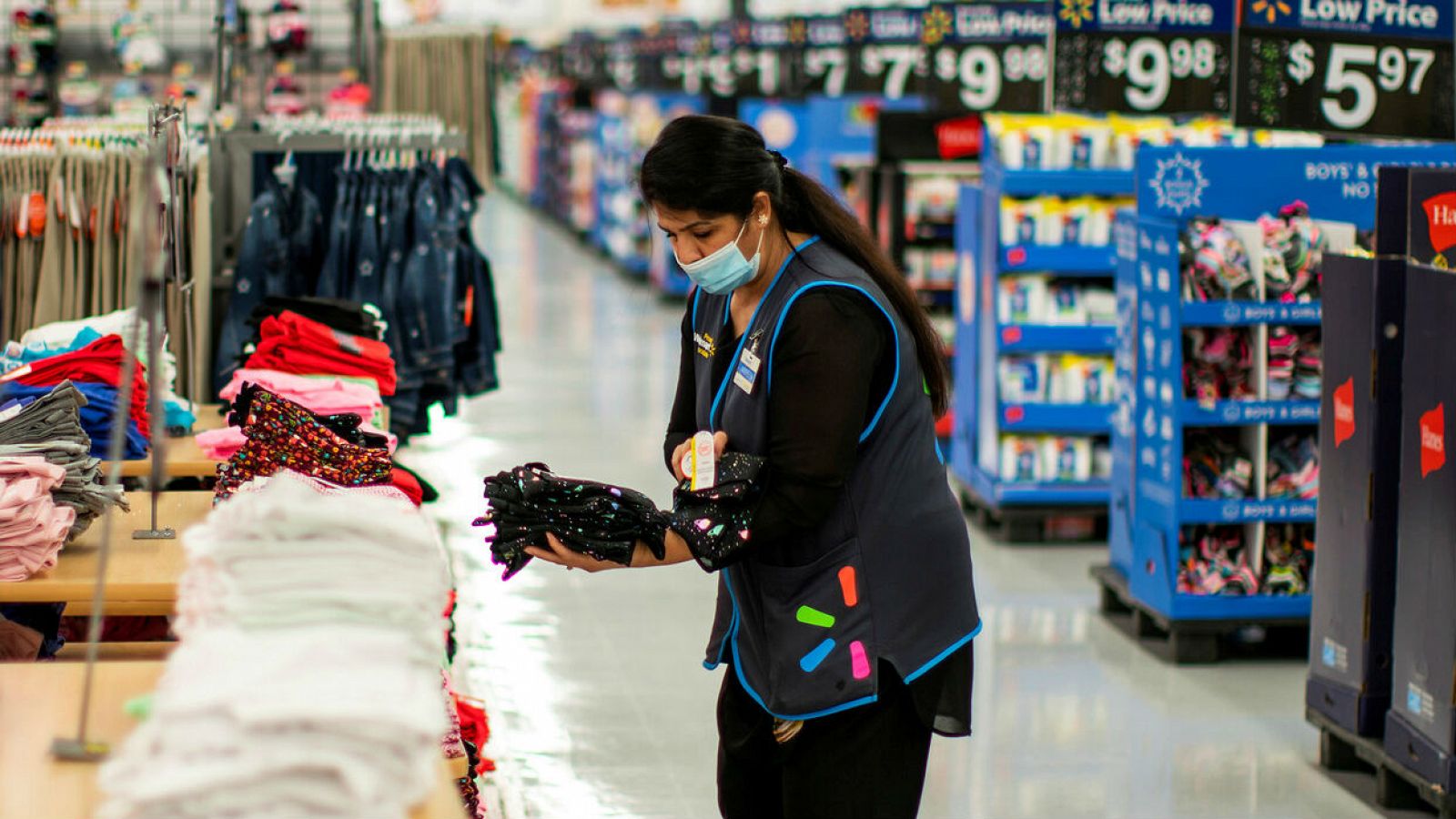 Una trabajadora usa una máscara mientras organiza productos en una tienda de North Brunswick, en Nueva Jersey, Estados Unidos.