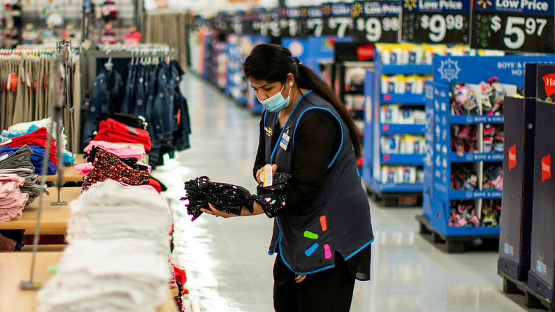 Una trabajadora usa una máscara mientras organiza productos en una tienda de North Brunswick, en Nueva Jersey, Estados Unidos.
