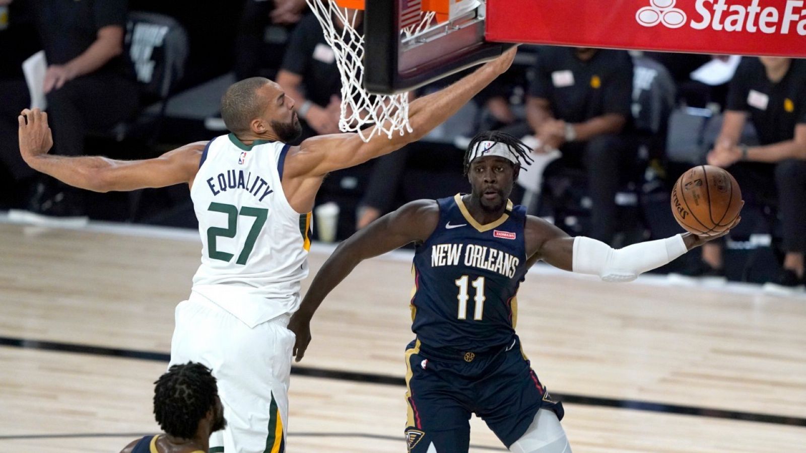 El jugador de los Pelicans de Nuev Orleans, Jrue Holiday (11) pasando al lado del jugador de los Jazz de Utah Rudy Gobert (27).