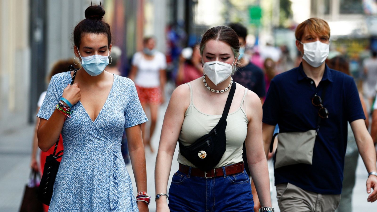 Jóvenes con mascarilla pasean por Madrid