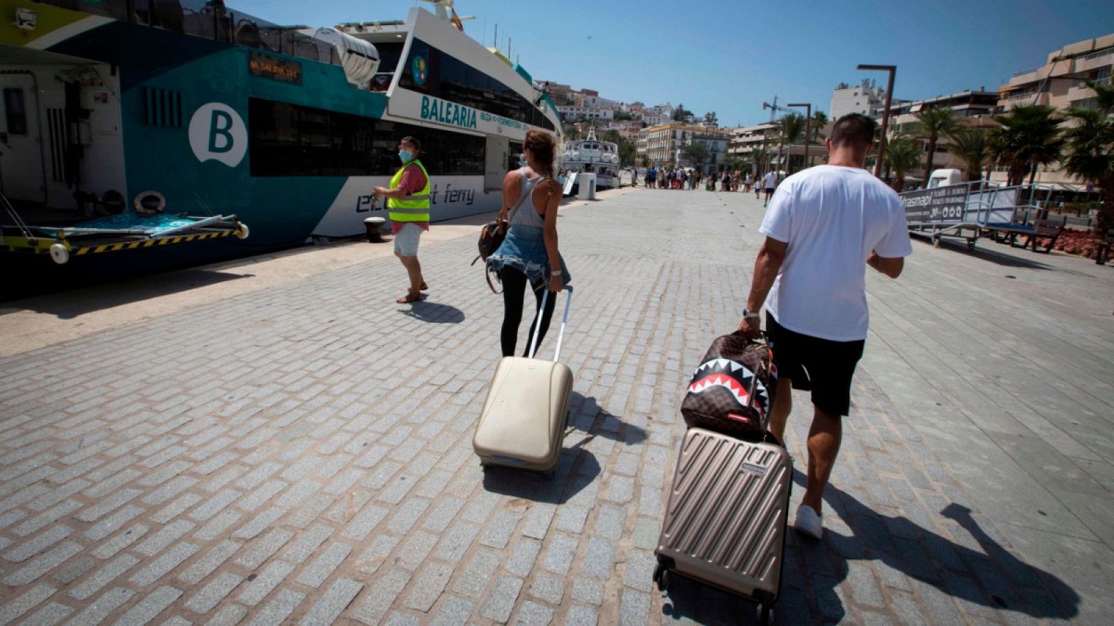 Dos turistas con maleta se disponen a coger un crucero