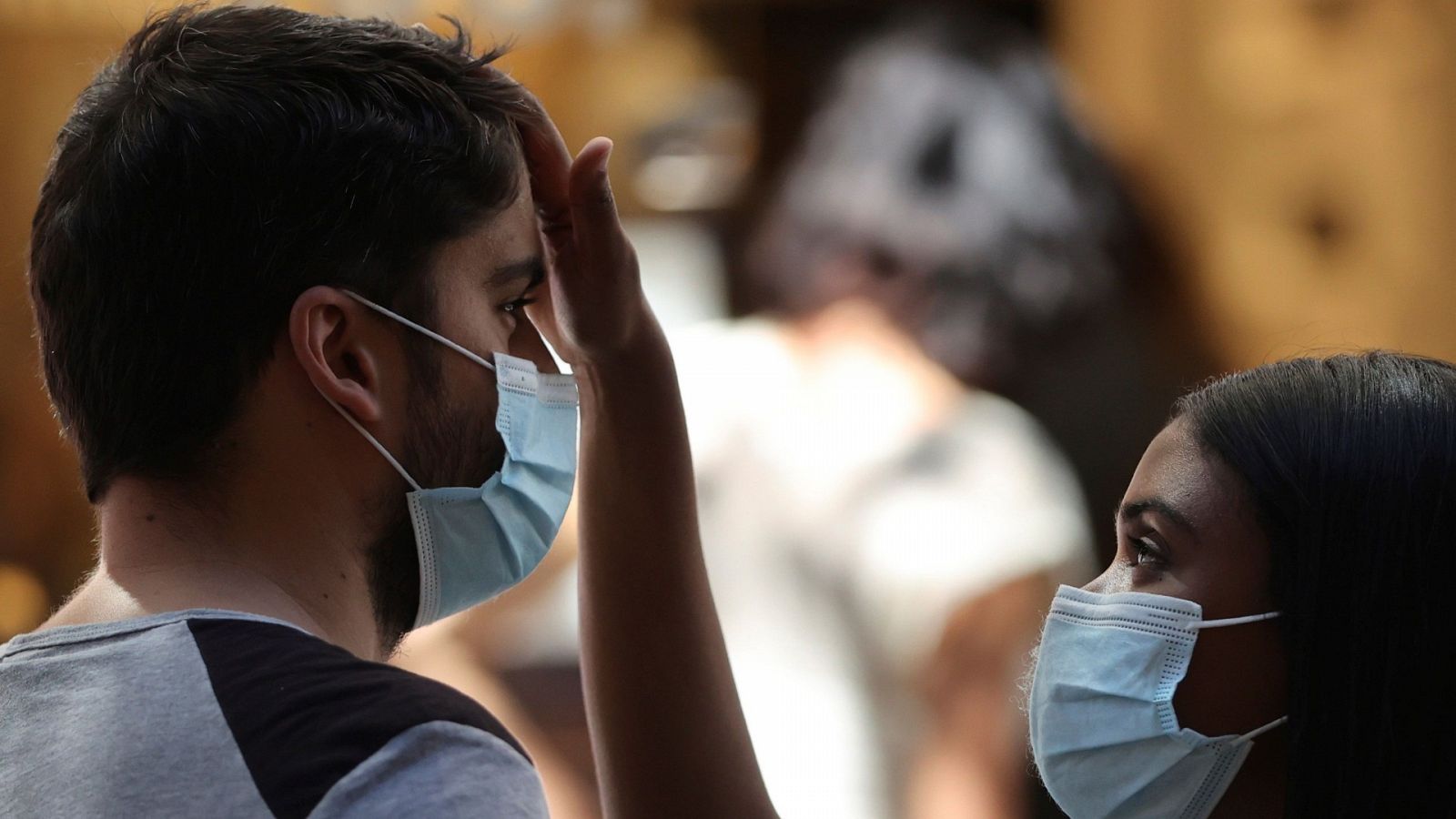 Pareja de jóvenes con mascarillas en Madrid durante la ola de calor
