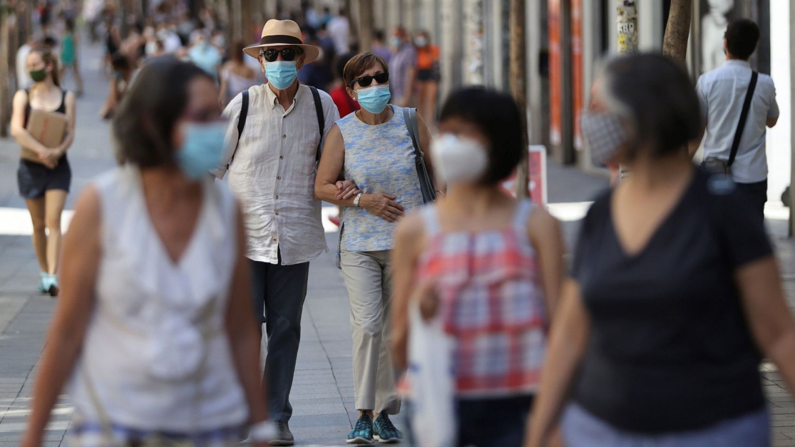 Dos personas pasean con mascarilla por Madrid