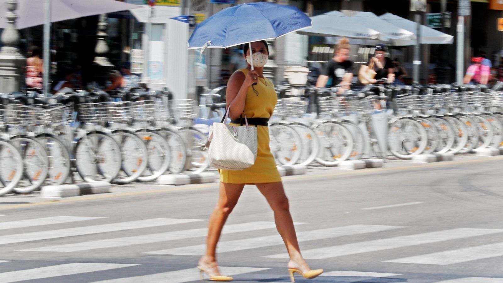 Una persona se protege del calor con una sombrilla en la ciudad de Valencia 