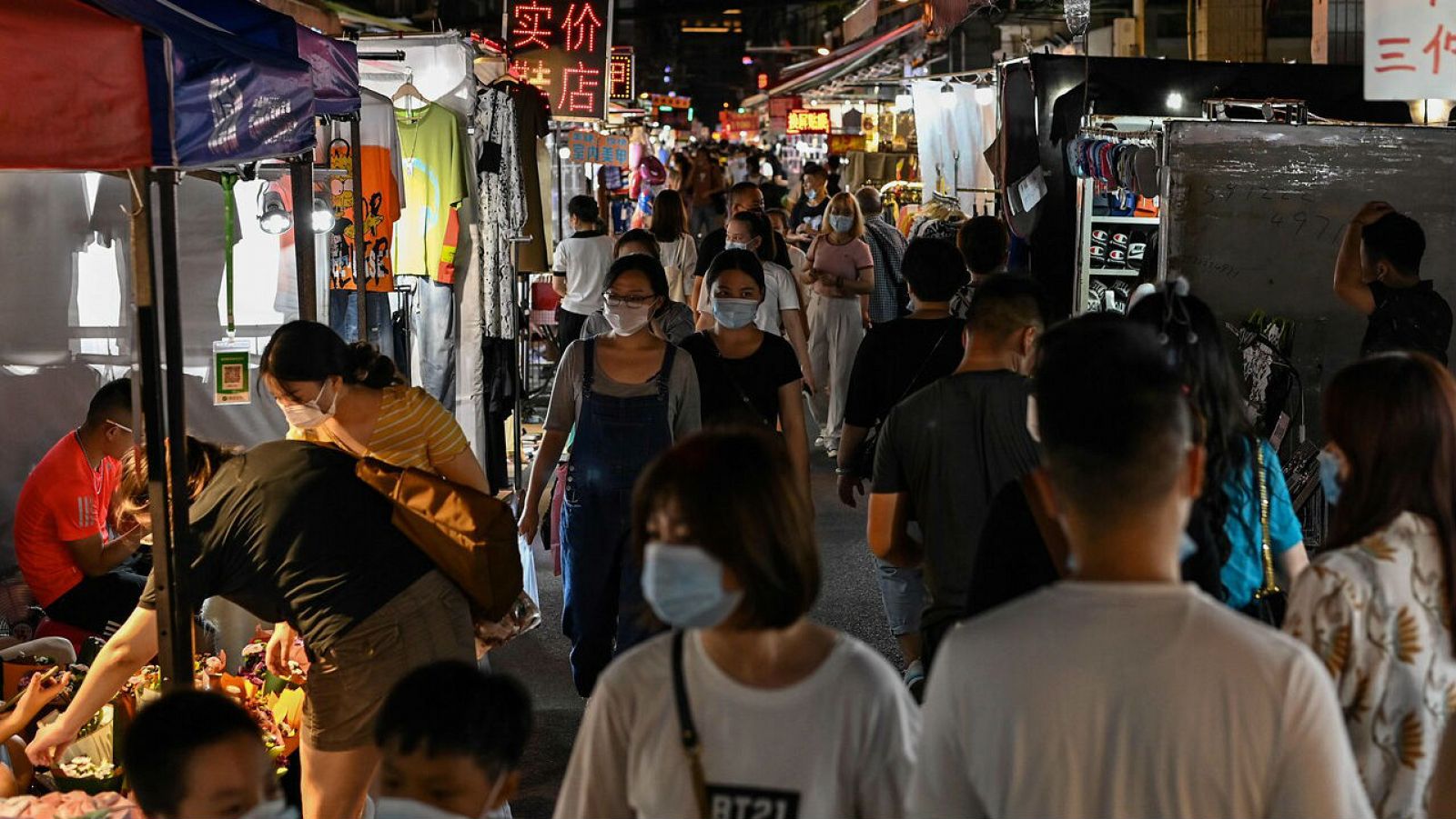 Personas caminando por un mercado nocturno en Wuhan, en la provincia central de Hubei, en China.
