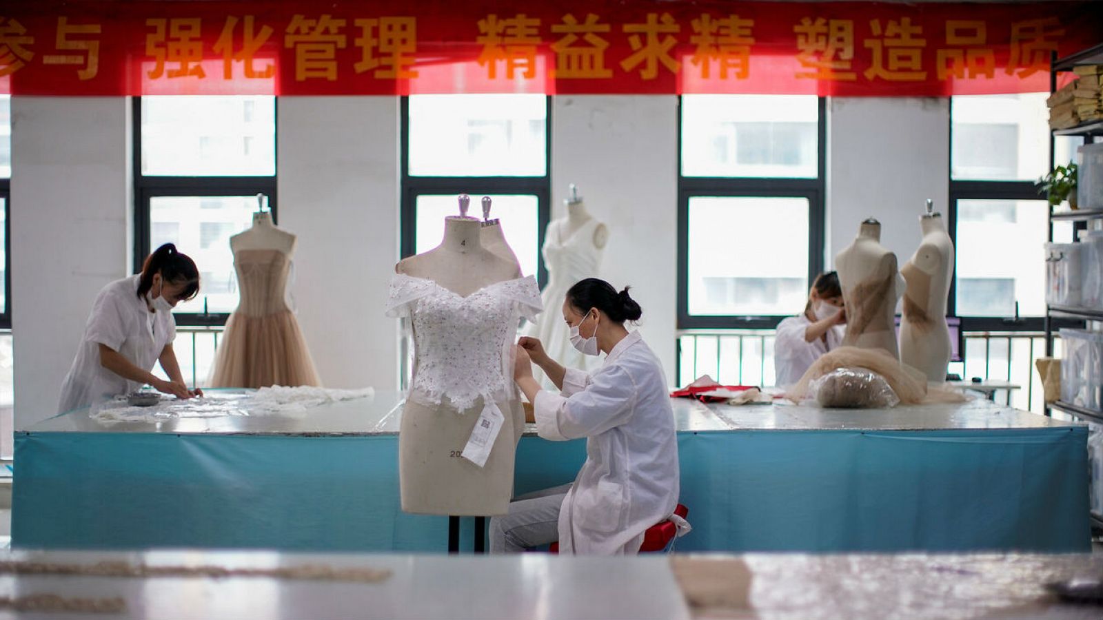 Empleados trabajan en prendas de vestir en una fábrica en Suzhou, provincia de Jiangsu, China.