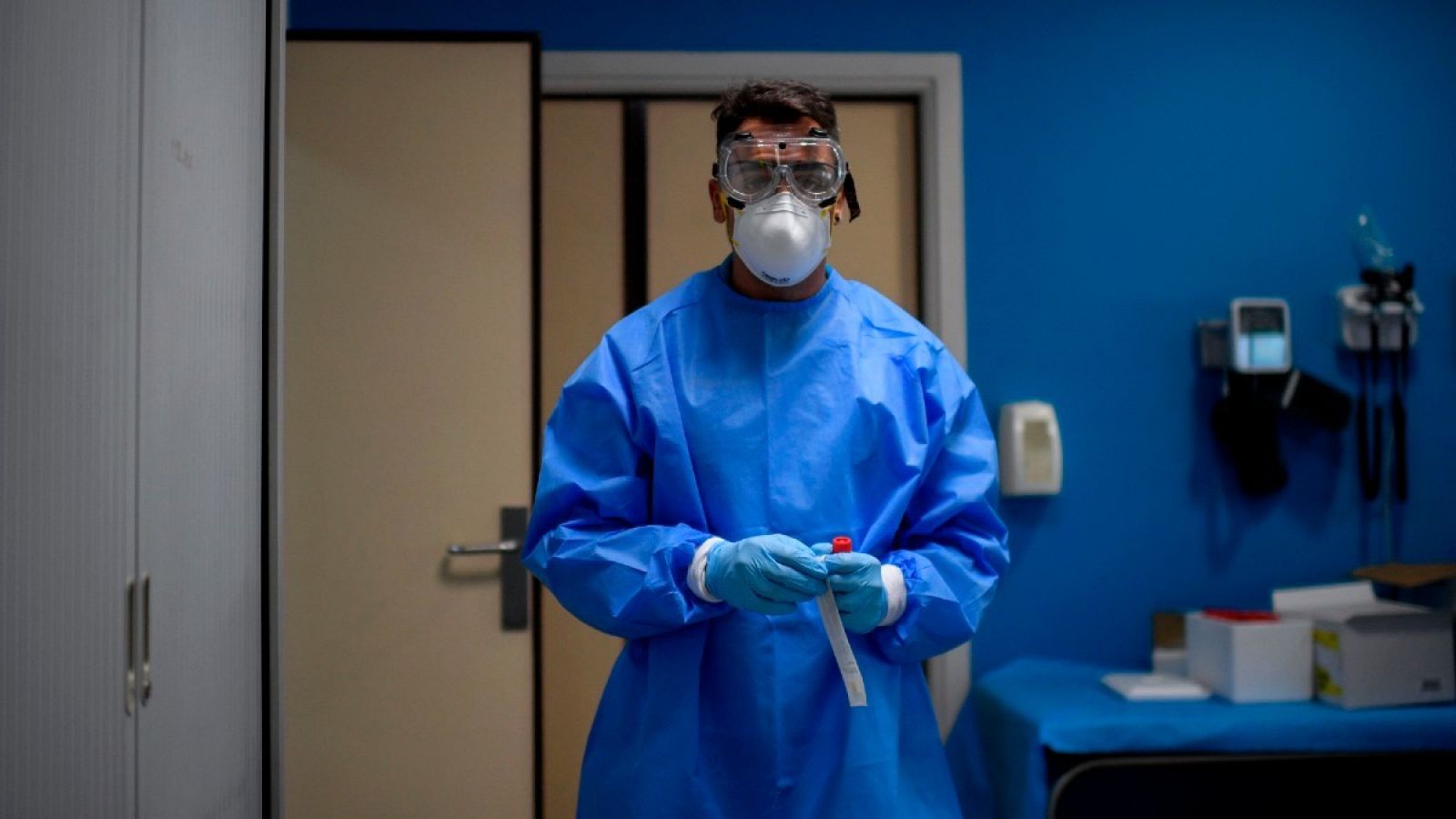 Un sanitario, con equipo de protección, sostiene una muestra en un centro de pruebas en Madrid, este agosto. 