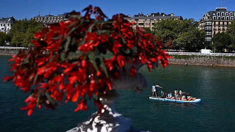 Turistas en una tabla de paddle en el río Urumea