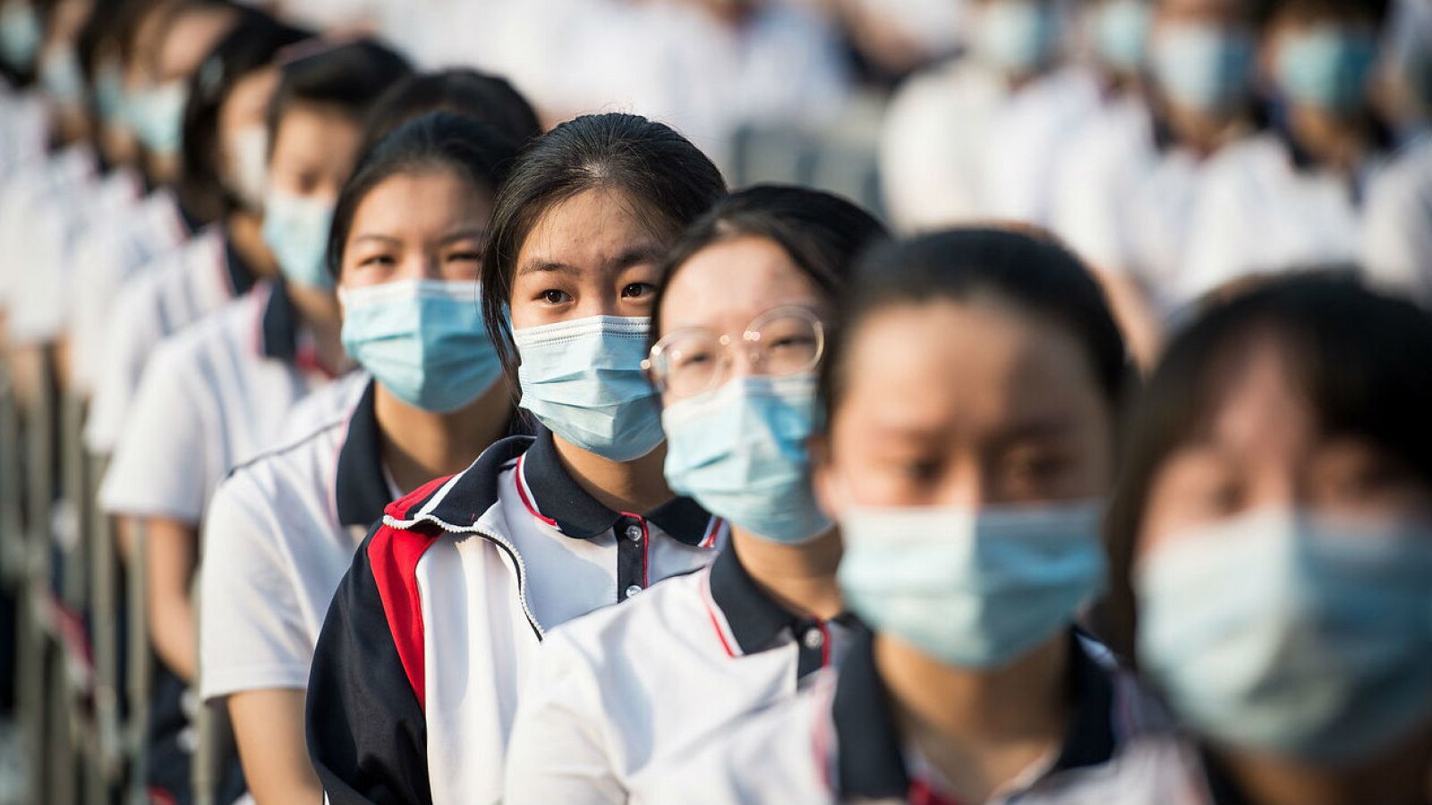 Estudiantes de la escuela secundaria de Wuhan con mascarillas se sientan mientras asisten a la ceremonia del nuevo semestre de otoño en Wuhan, provincia de Hubei, China. 