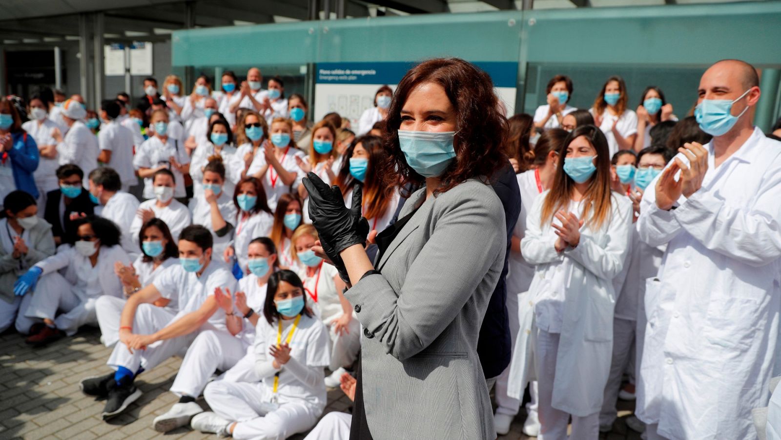 La presidenta madrileña aplaude en el acto de cierre del hospital de Ifema