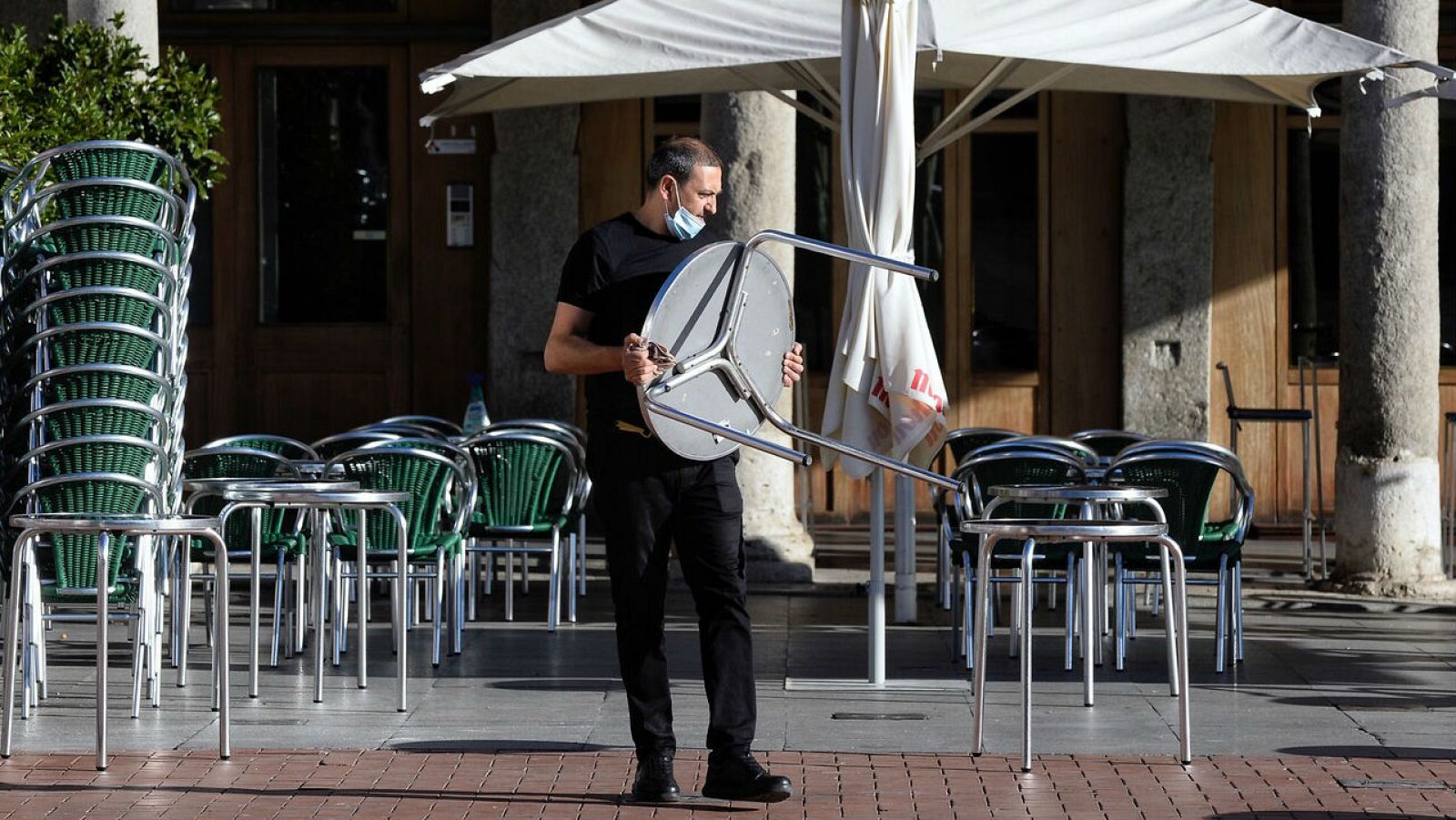 Un camarero coloca las mesas en una terraza en Valladolid.