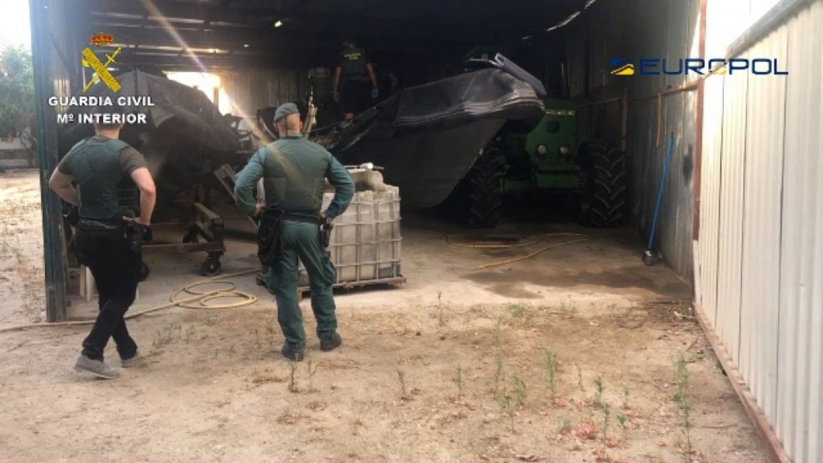 Dos agentes de la Guardia Civil observan una narcolancha incautada en la Operación Tortilla