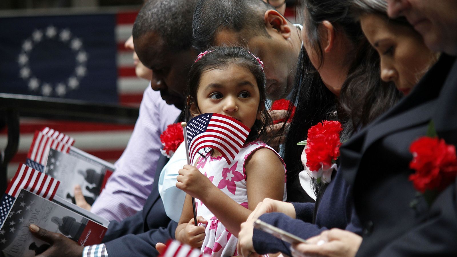 La hija de un inmigrante sostiene una bandera estadounidense.