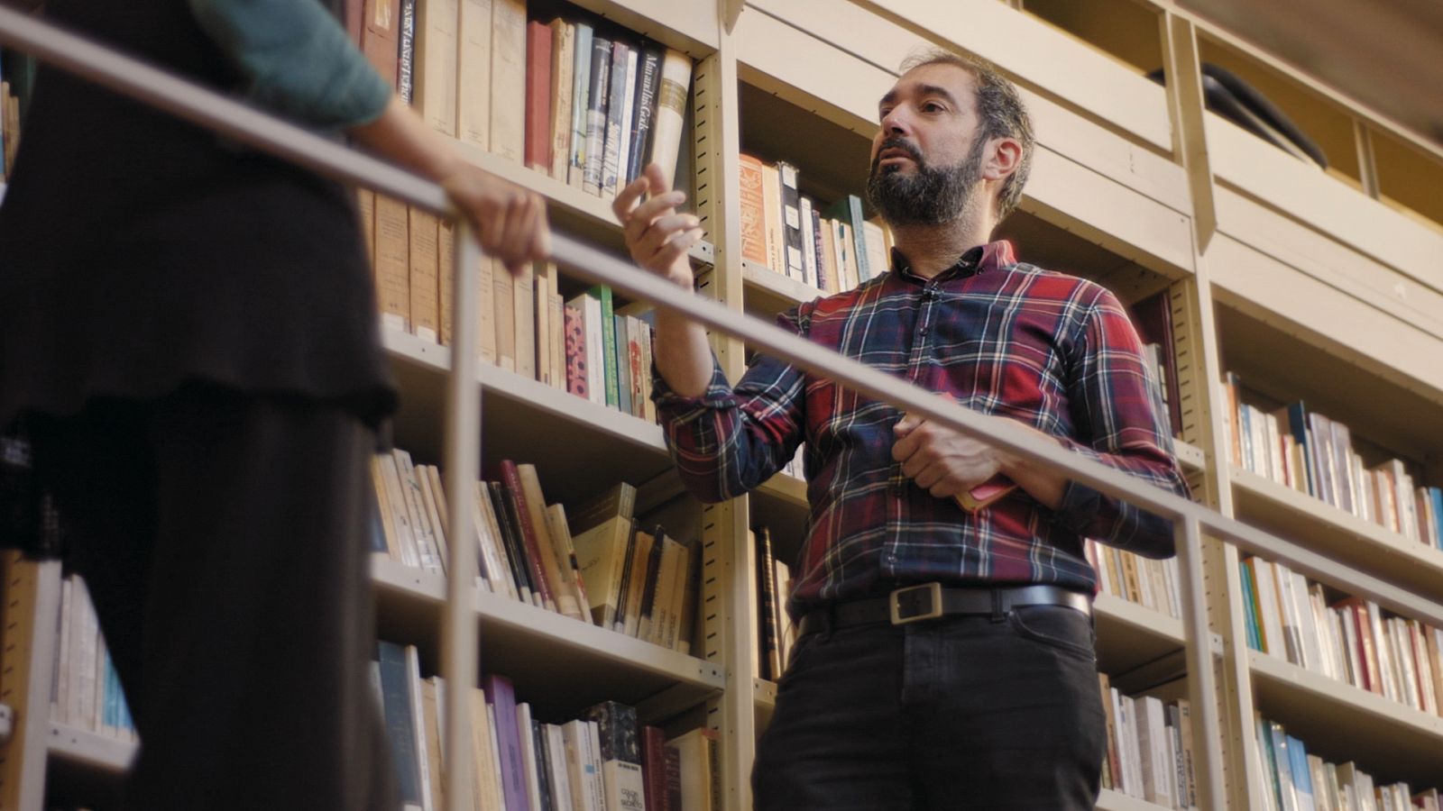 Pere Estupinyà, de pie, en una entrevista para El Cazador de Cerebros dentro de una biblioteca