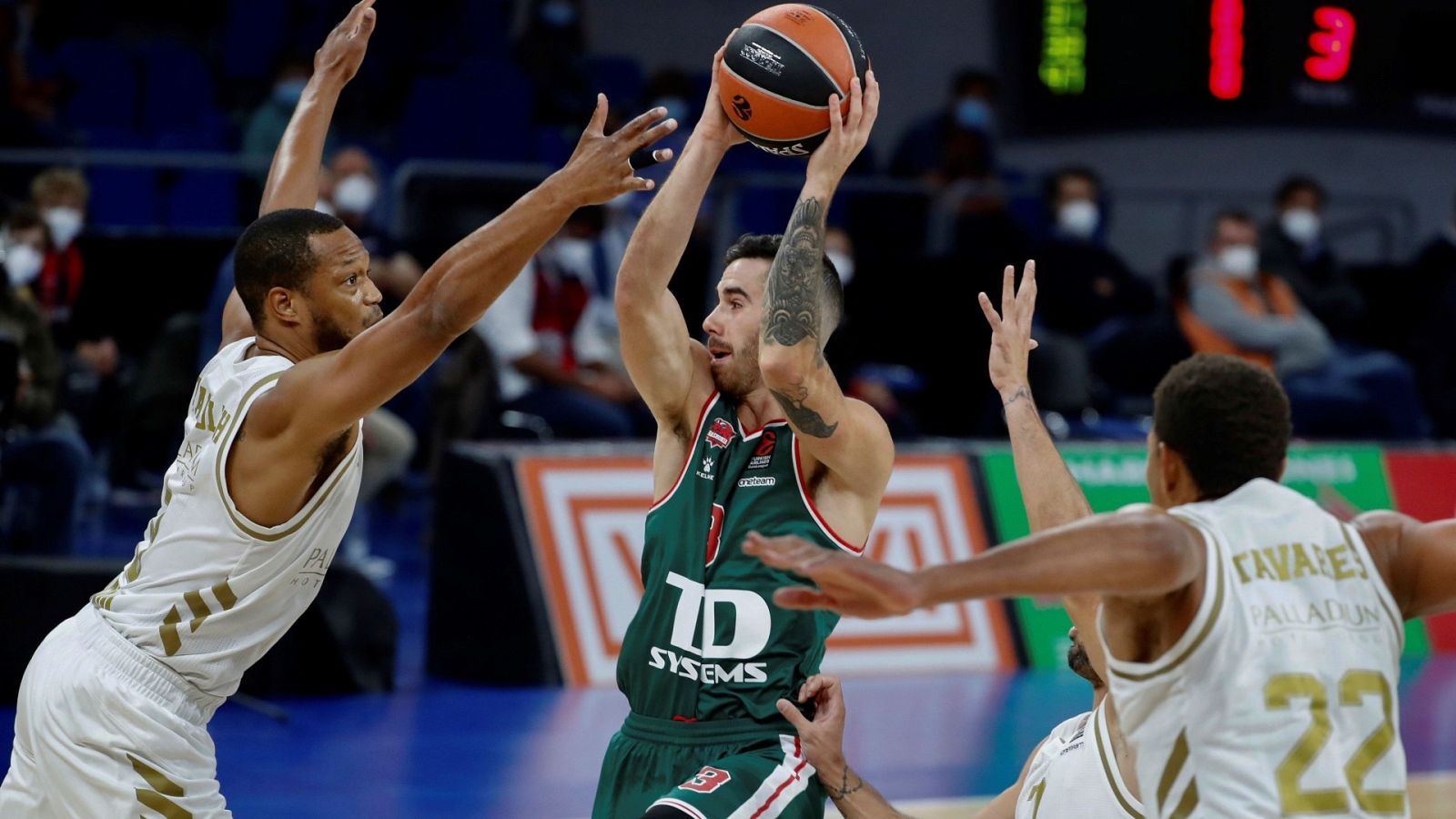  El base argentino del Baskonia Luca Vildoza (c) entra a canasta defendido el ala-pívot alemán Anthony Randolph (i), del Real Madrid
