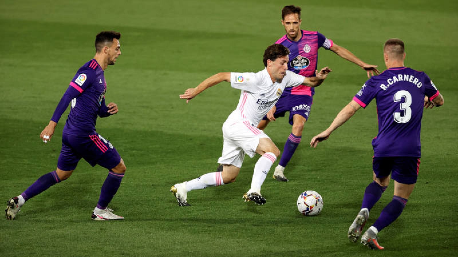 Álvaro Odriozola (c) controla el balón entre tres jugadores del Valladolid