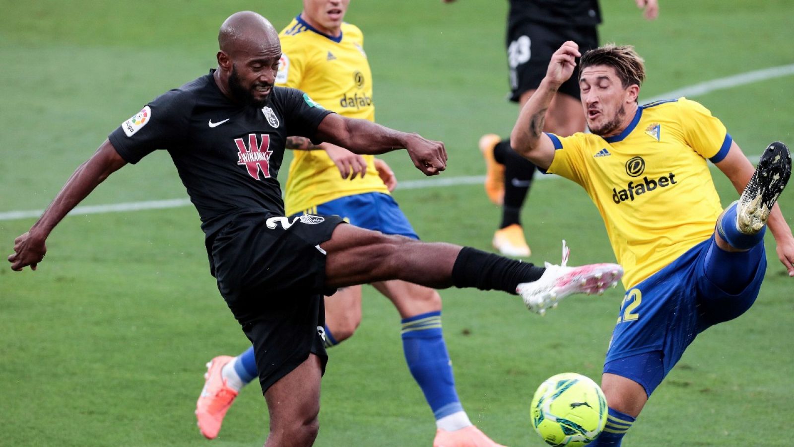 El defensa francés del Granada CF, Dimitri Foulquier (i) pelea un balón con el defensa del Cádiz Luis Espino.