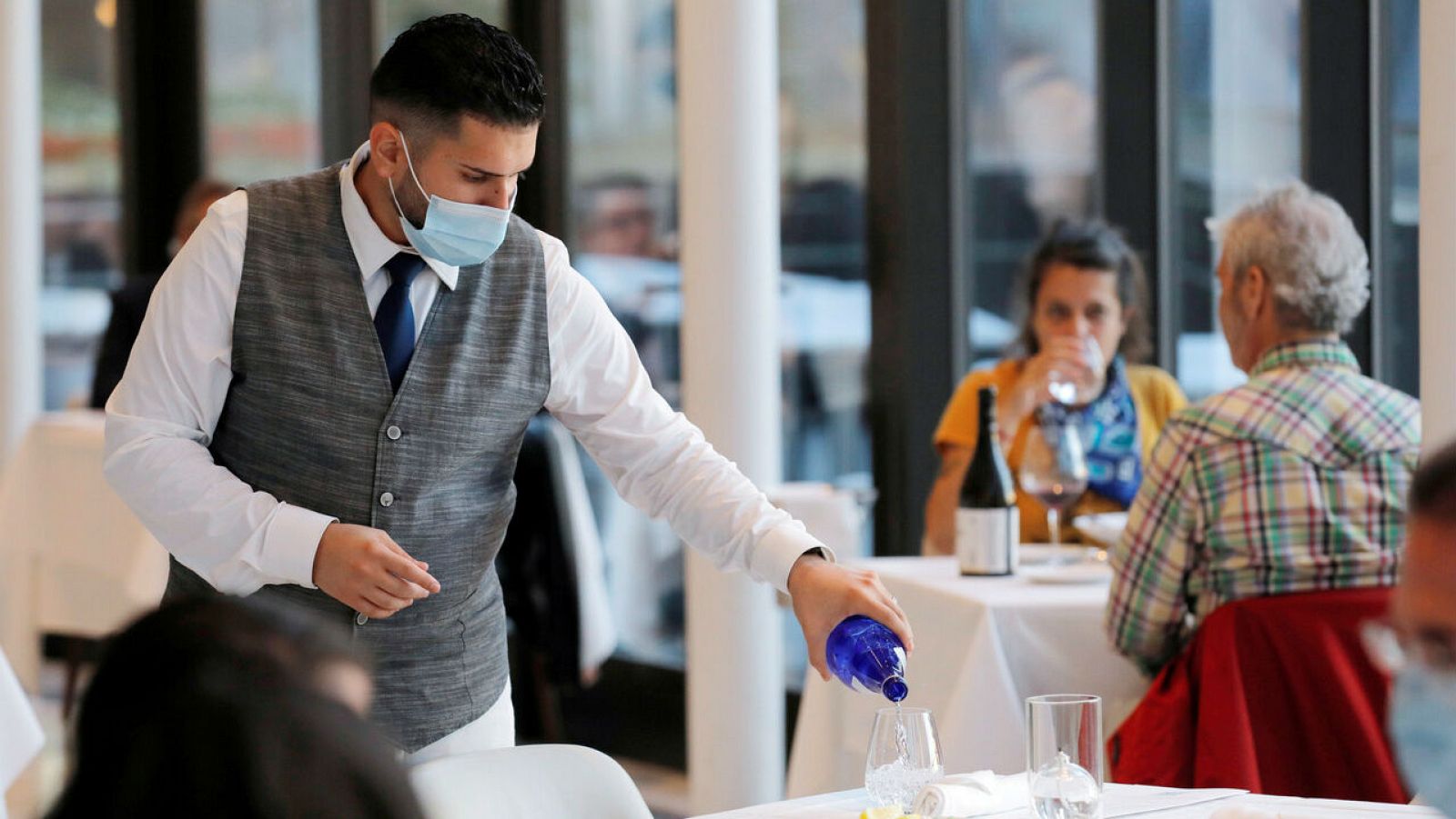 Un camarero llena un vaso en un restaurante en Manhattan, Nueva York, Estados Unidos.