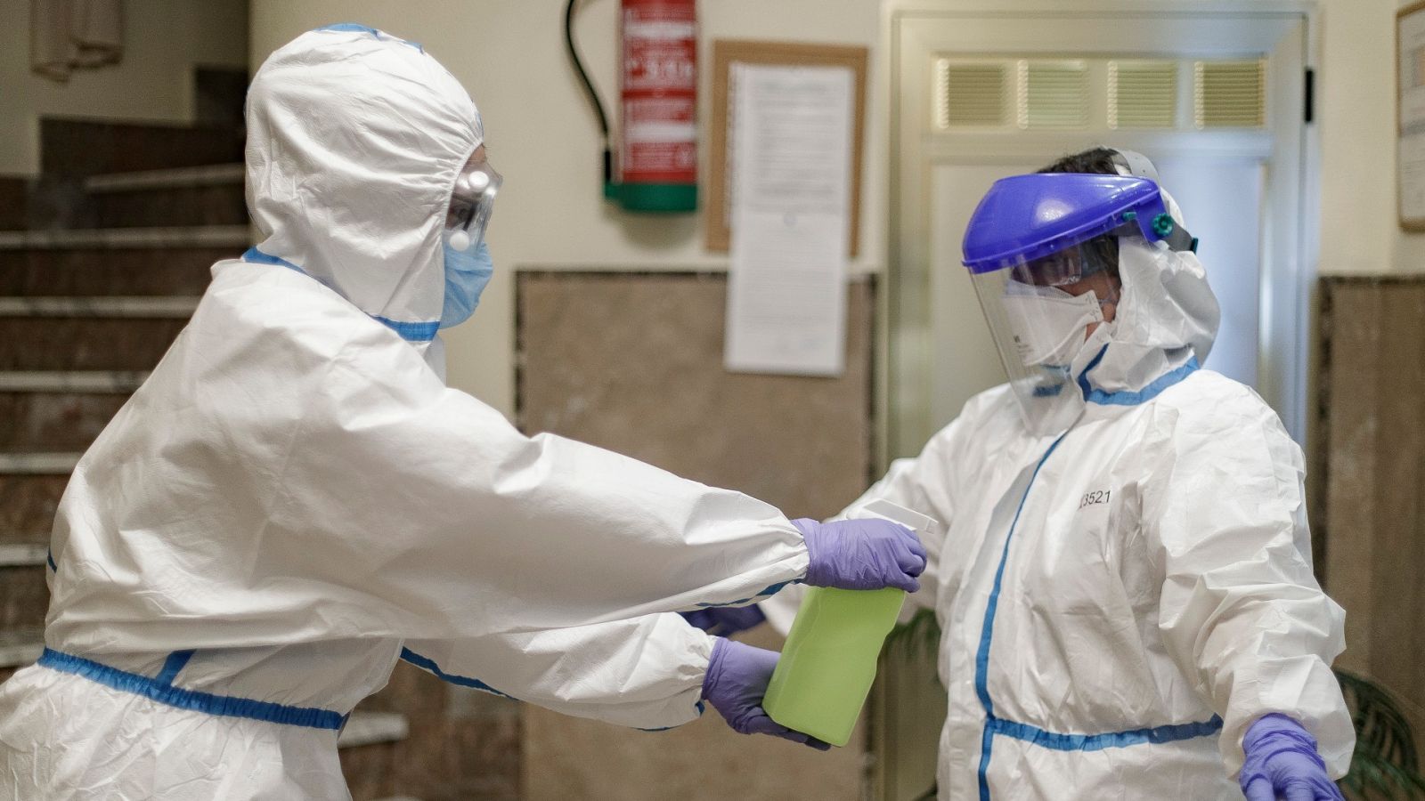 Una trabajadora desinfecta a un médico en el interior de una residencia de mayores.