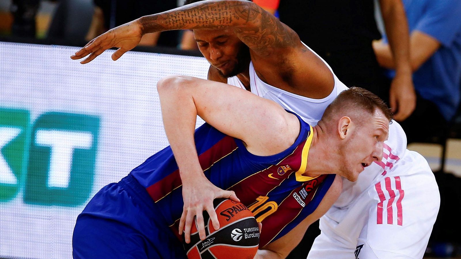 El alero letón del Barça Rolands Smits lucha con Trey Thompkins, del Real Madrid.