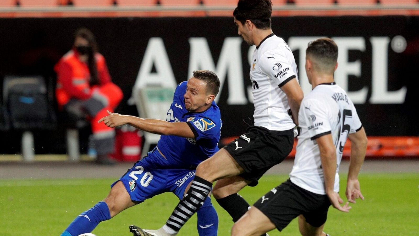 El centrocampista esloveno del Getafe, Nemanja Maksimovic (i), intenta superar a los jugadores del Valencia, Carlos Soler (c) y Hugo Guillamón