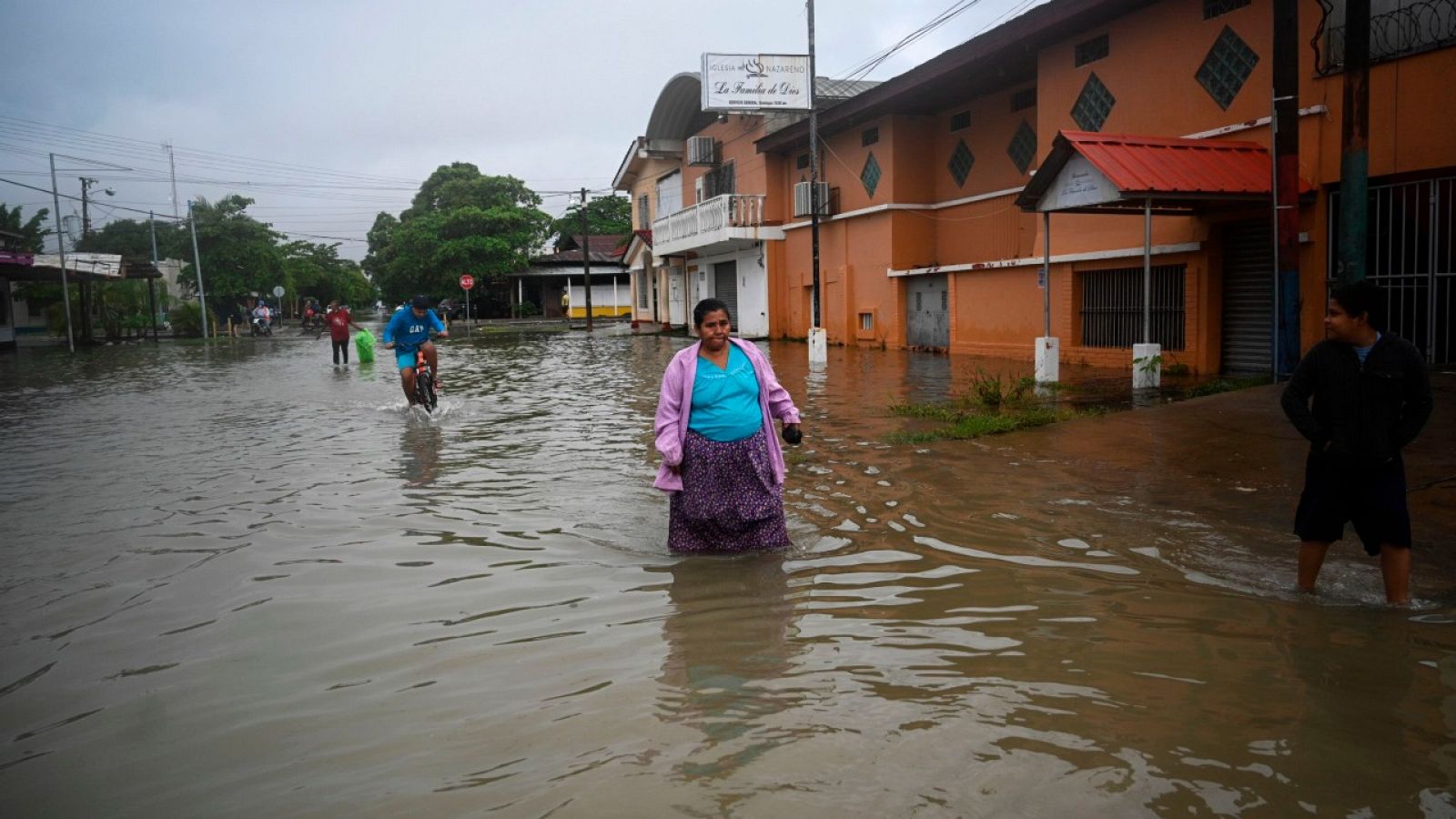 Gente andando por una calle inundada en el municipio de Puerto Barrios, Izabal, a unos 310 kilómetros al noreste de Ciudad de Guatemala.