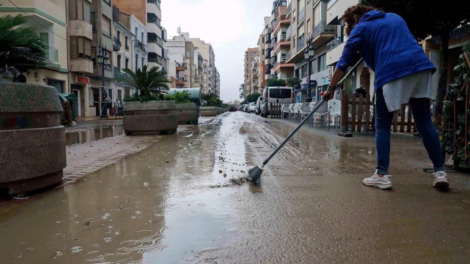 Una vecina retira agua de la calle, en Cullera (Valencia), donde han caído mas de 100 litros