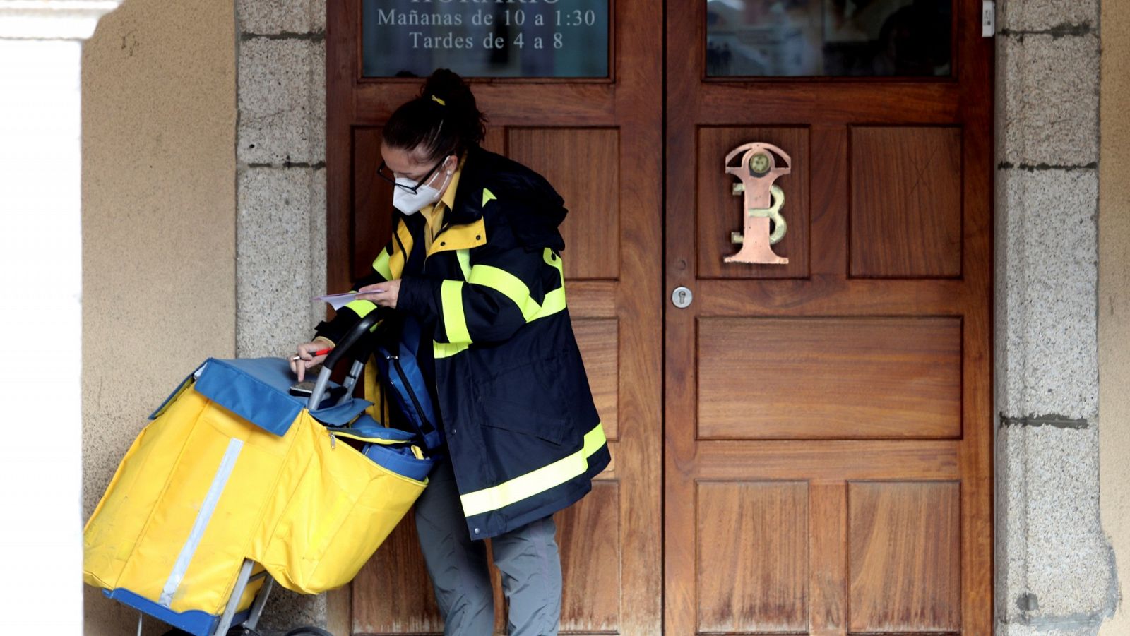 Una trabajadora de Correos entrega unas cartas en Ponferrada