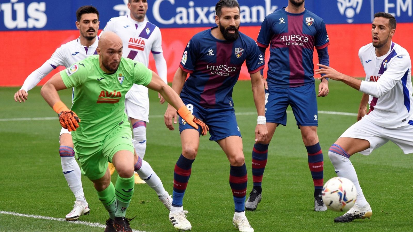 El defensa griego del Huesca Dimitrios Siovas (c), y el portero serbio del Eibar Marko Dimitrovic.