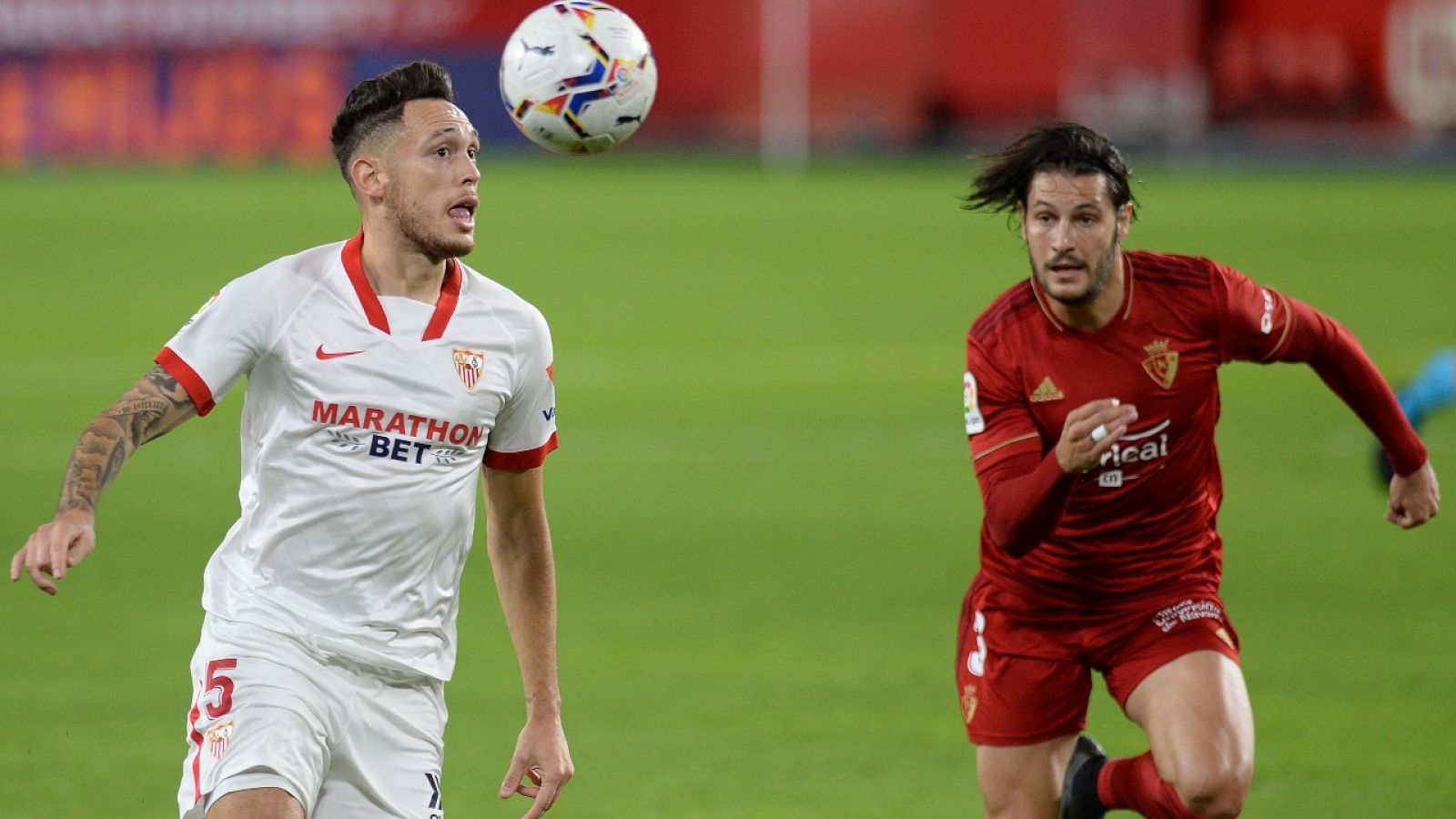 El jugador del Sevilla Lucas Ocampos lucha por un balón ante el futbolista de Osasuna Juan Cruz.