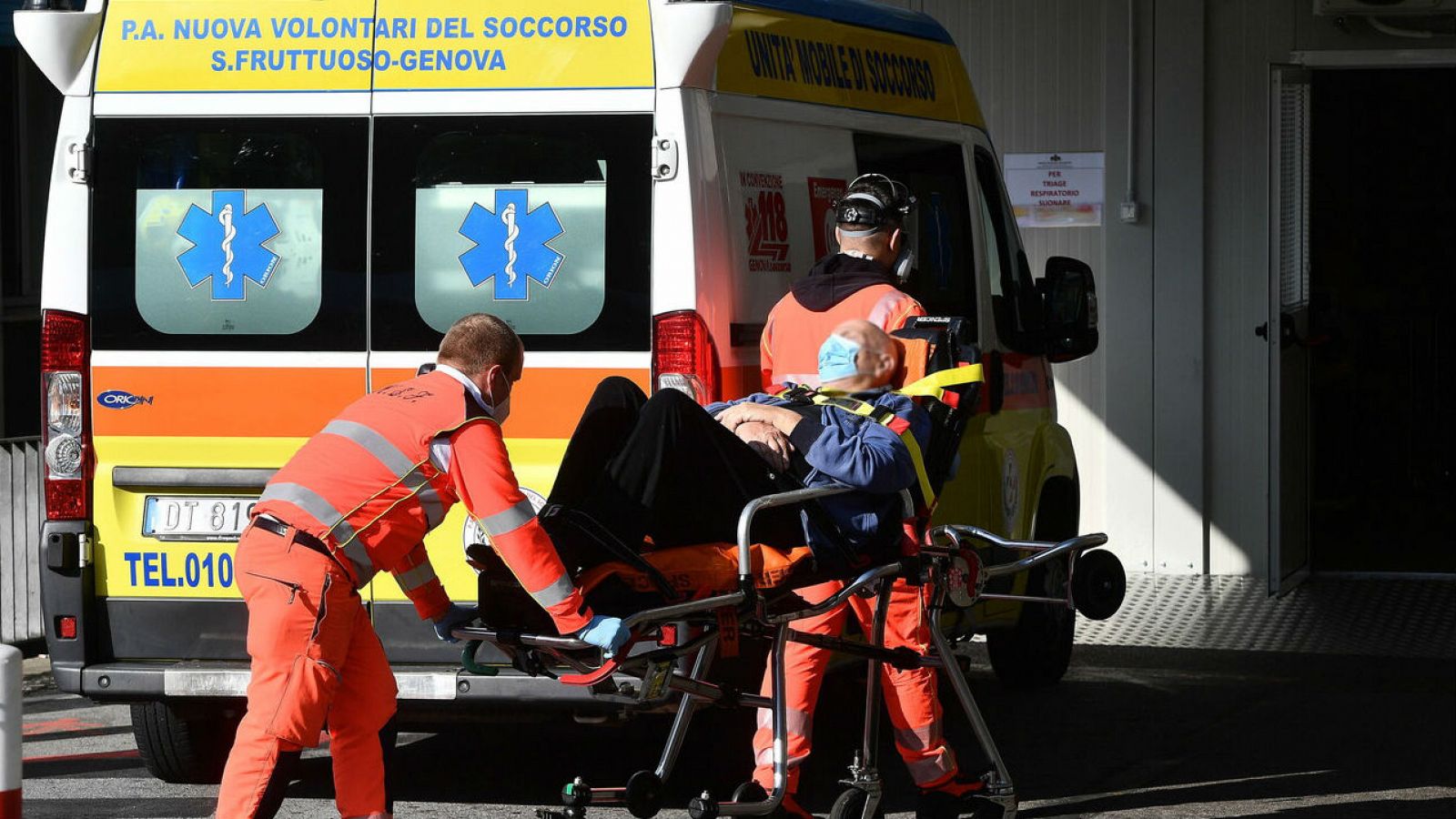 Trabajadores sanitarios con equipos de protección trasladan a un paciente con COVID-19 en el hospital policlínico San Martino, Génova, Italia.