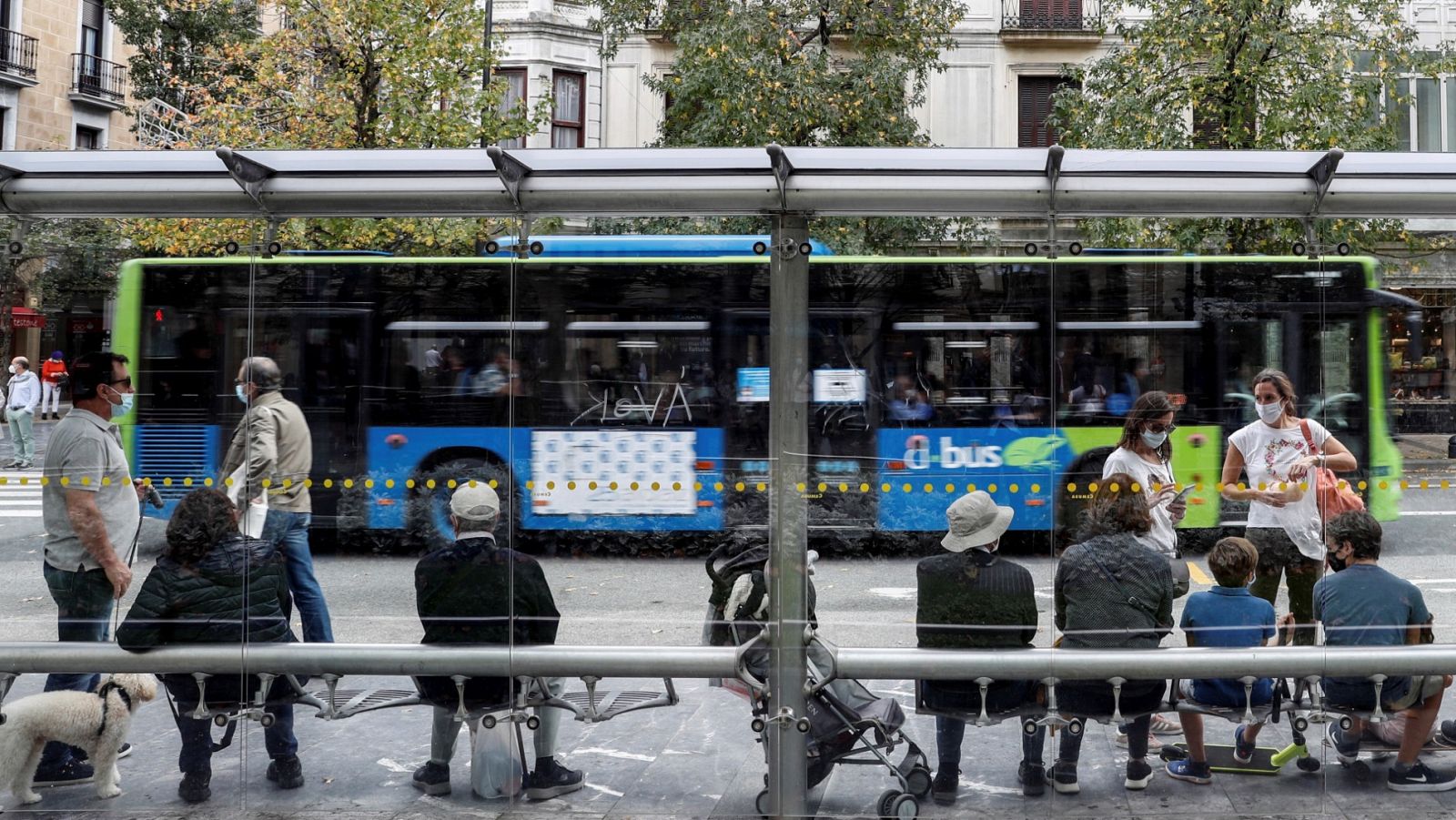 Un grupo de personas espera en la parada de autobús de San Sebastián