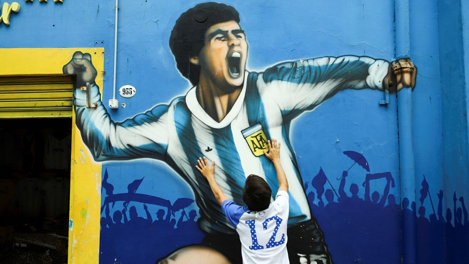 Un seguidor frente a un mural en homenaje a Maradona