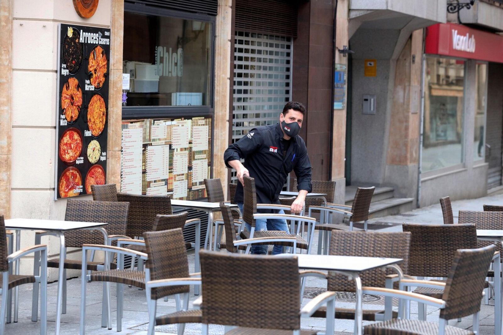 Un camarero prepara la terraza de un bar de Salamanca