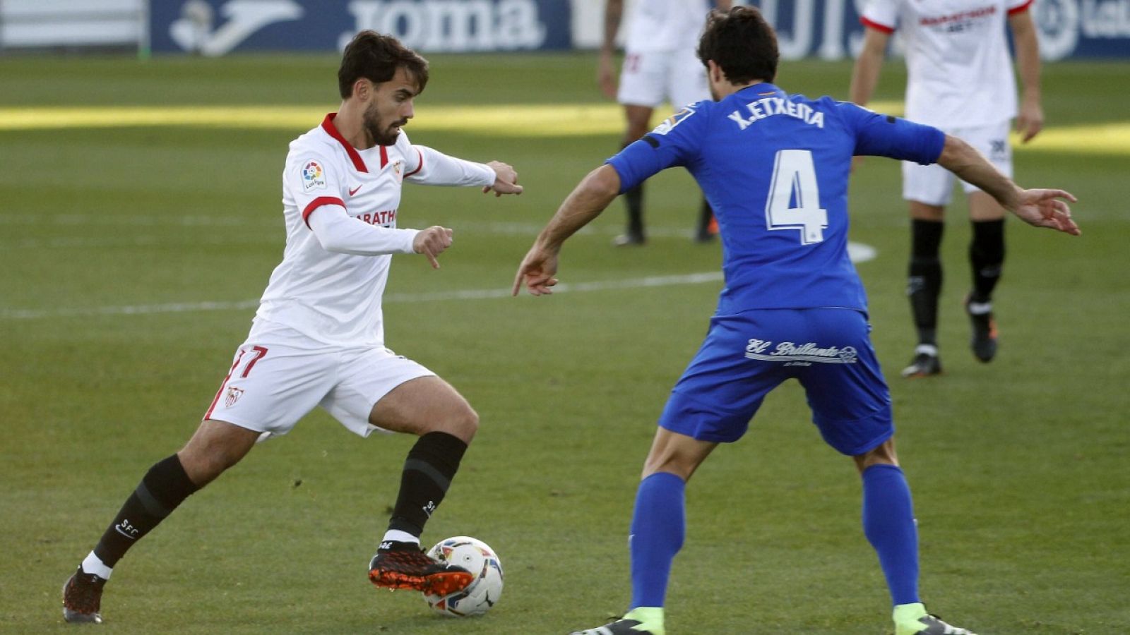 El delantero del SEvilla Suso (i) y el defensa del Getafe Xabier Etxeita luchan por un balón.