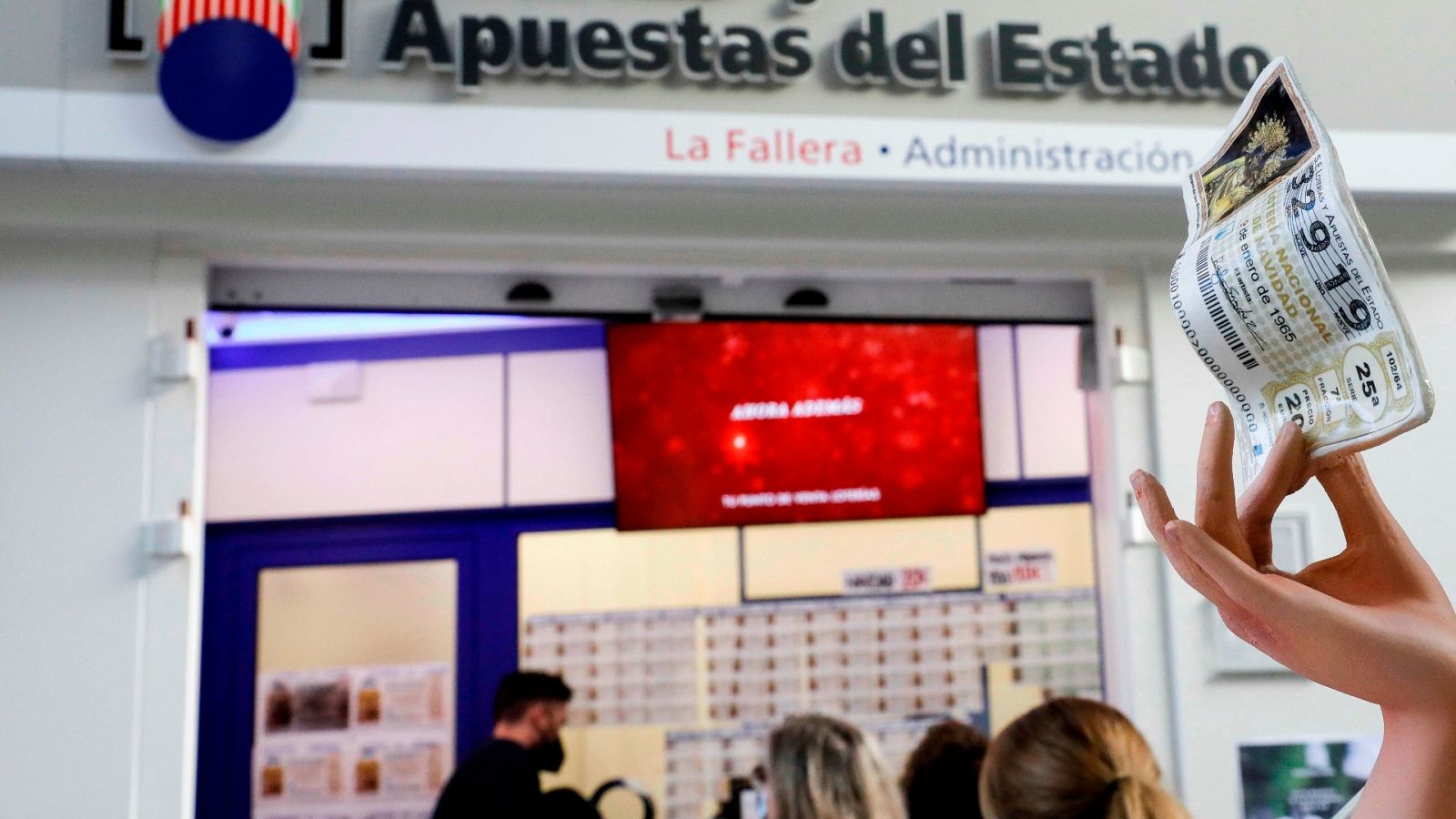 Varias personas guardan cola en una administración de Lotería de Valencia