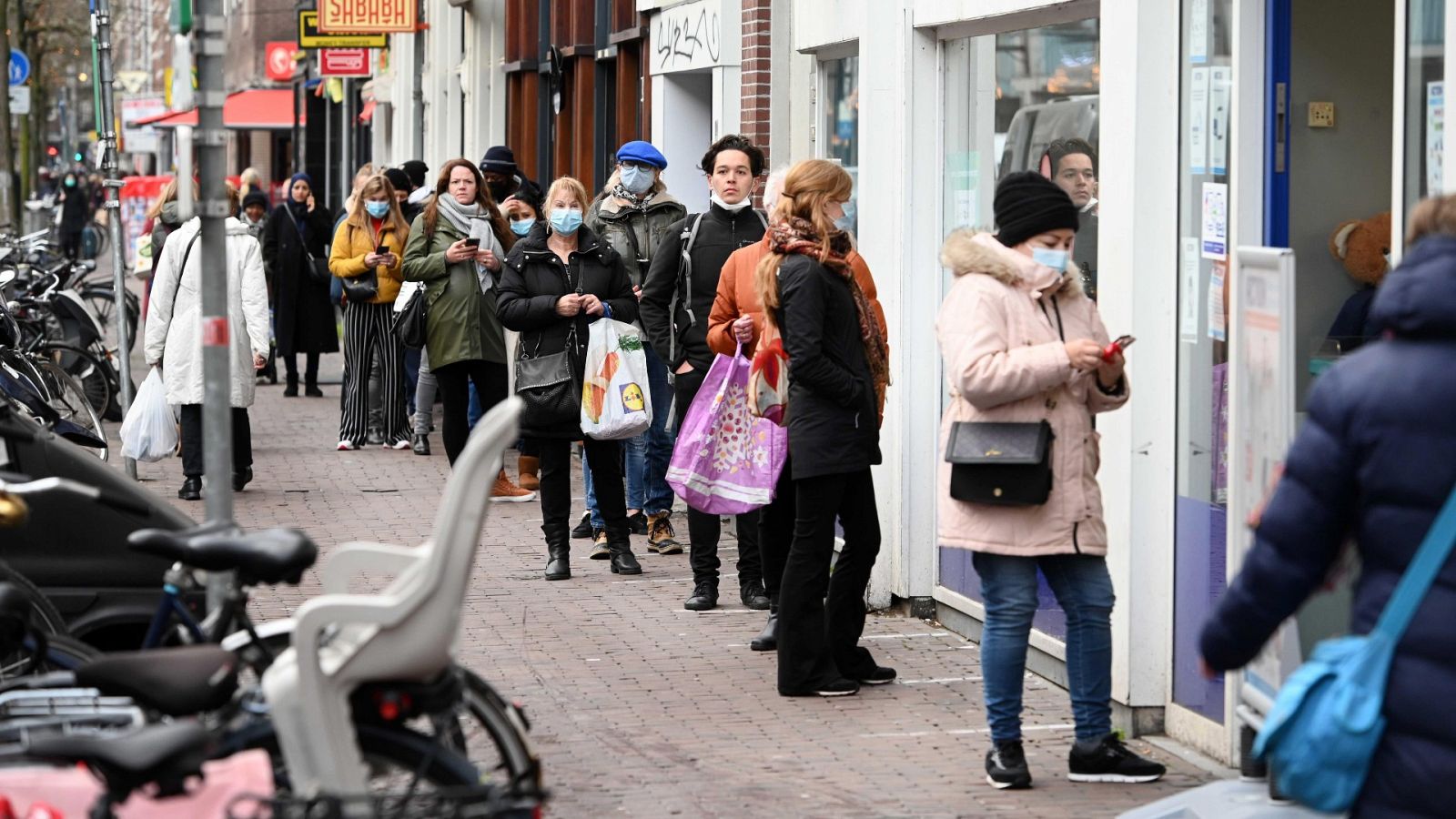 Ciudadanos guardan cola en una calle en el centro de Amsterdam.