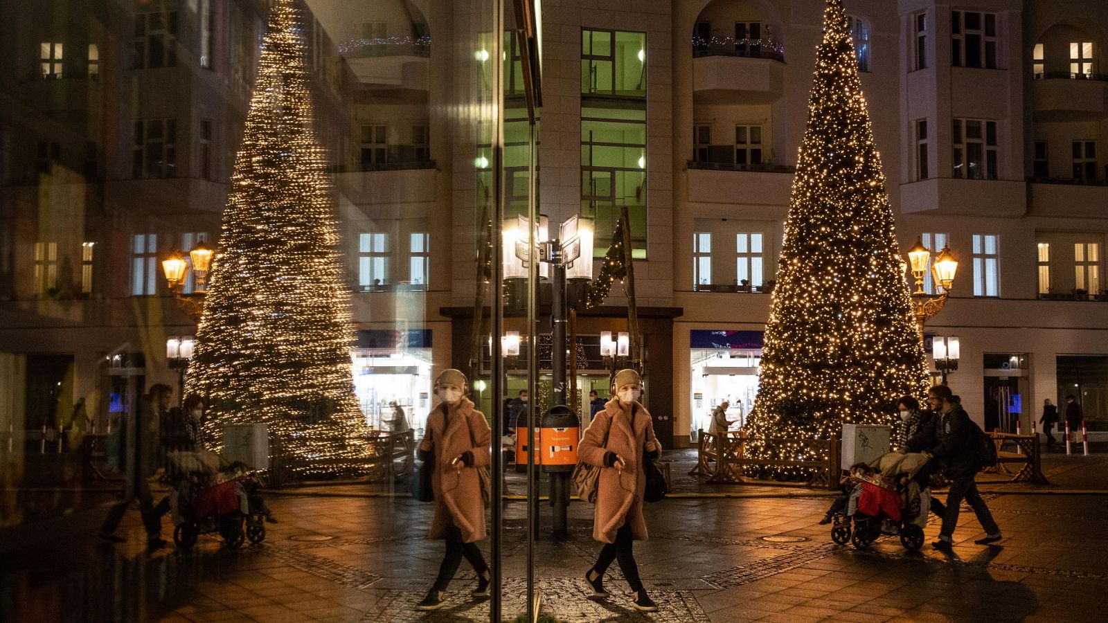 Varias personas pasan por delante de un árbol de Navidad en una calle de Berlín