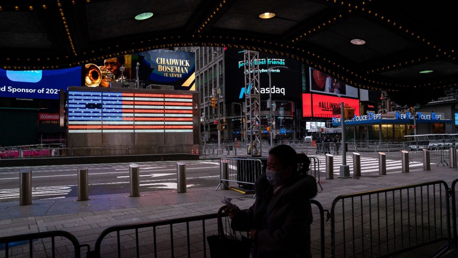 Una mujer con mascarilla caminando por Times Square, Nueva York.