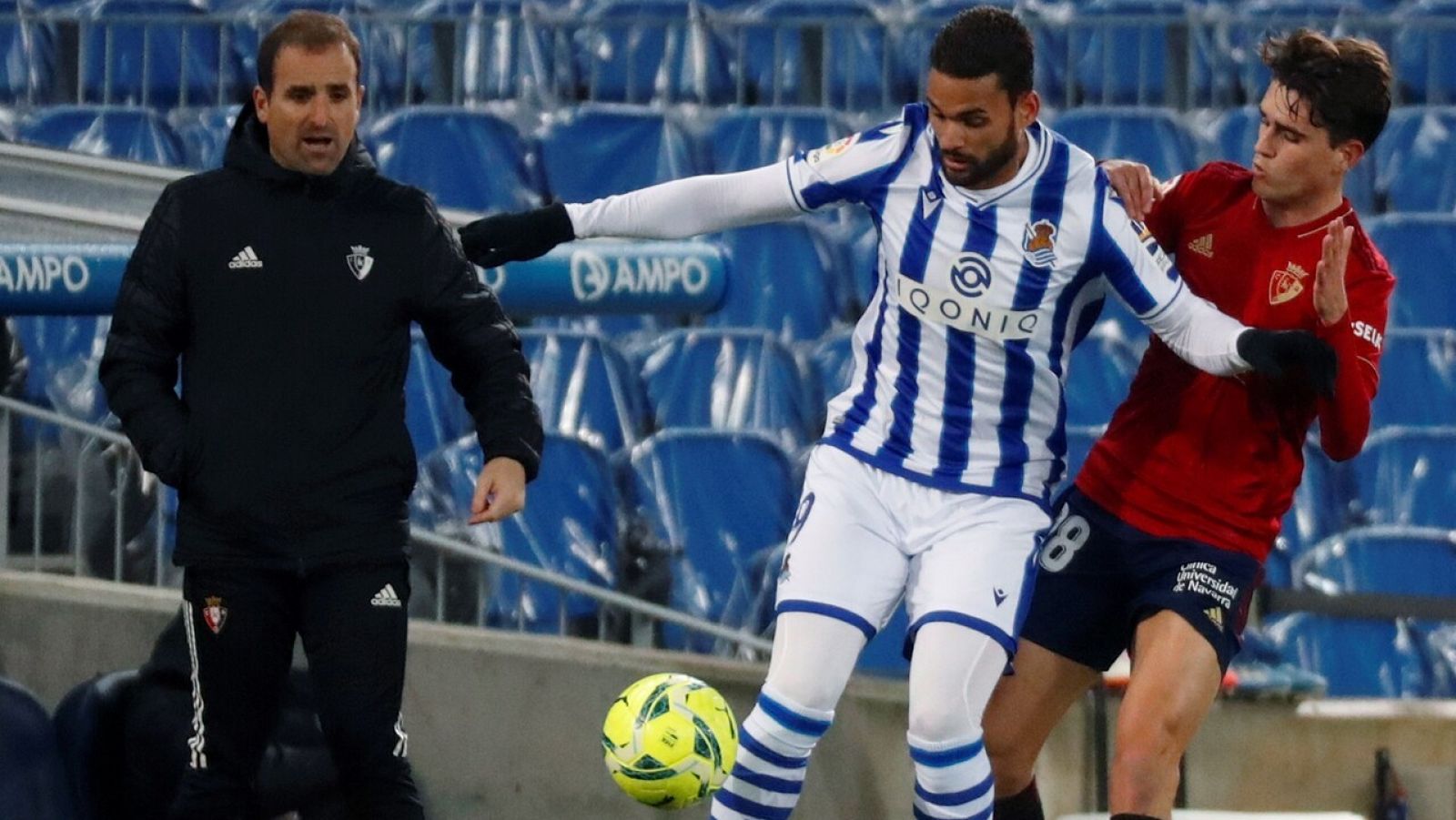 Willian José (i), de la Real, conduce el balón ante la presión de Roberto López, de Osasuna.