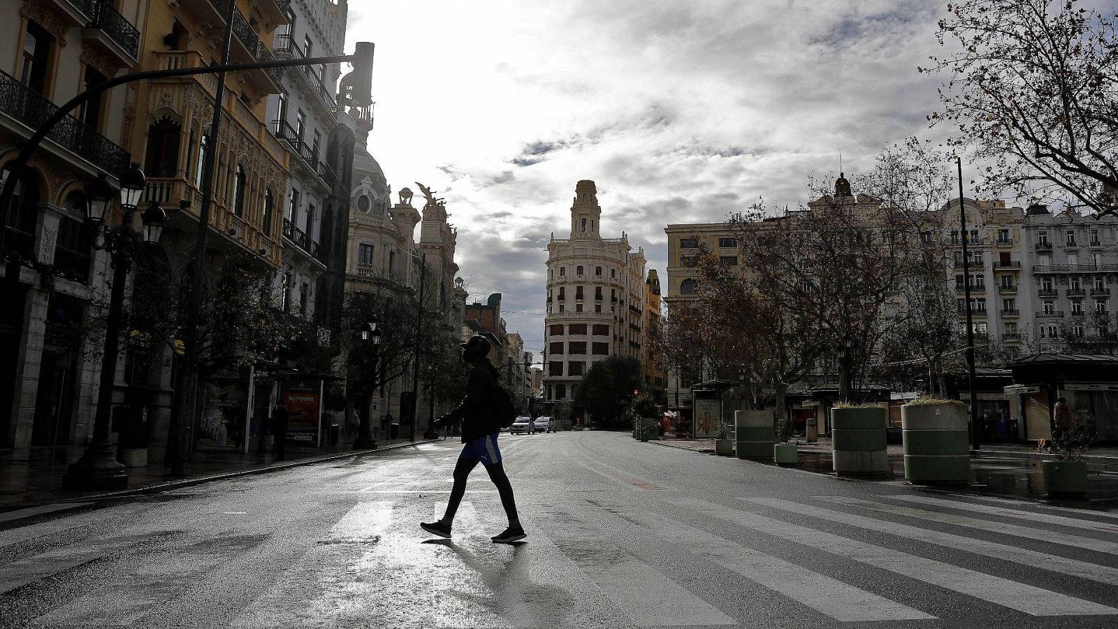 Un hombre cruza un paso de cebra en el centro de Valencia