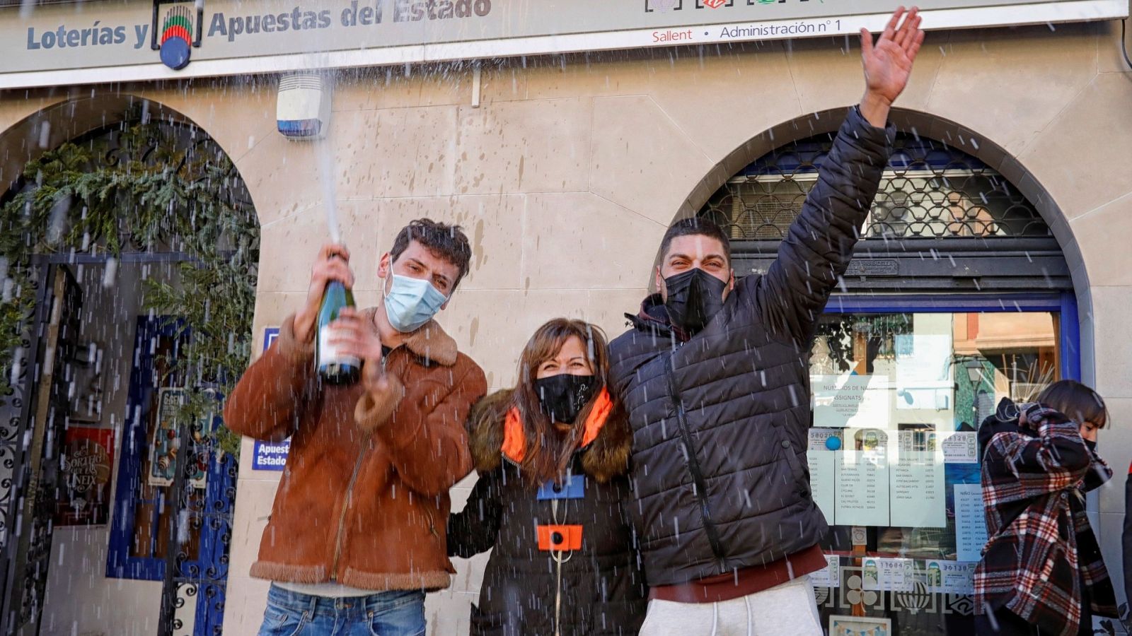 La encargada de la administración (c), uno de los agraciados (d) y algunos amigos celebran el primer premio de la Lotería del Niño vendido en la Administración número 1 de Sallent. v